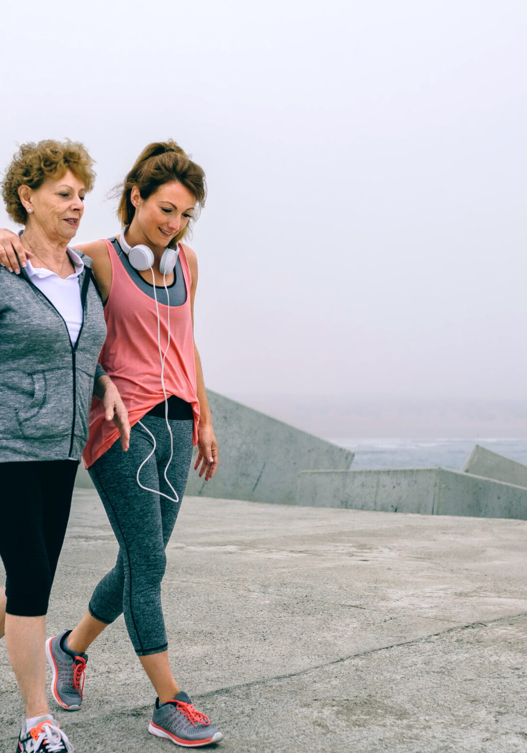 Two women walking by sea pier